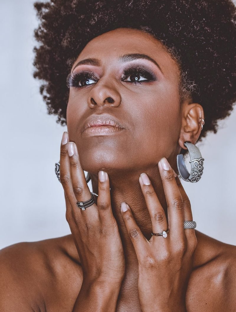 A woman with a raised chin and statement earrings.